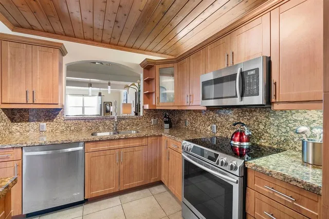 a kitchen with stainless steel appliances granite countertop a sink stove and microwave