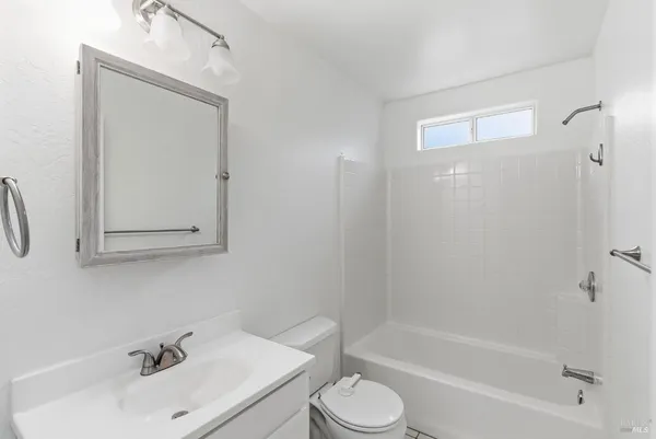 a kitchen with a sink cabinets stainless steel appliances and windows