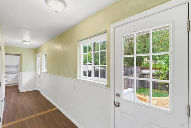 a view of a big room with wooden floor and windows