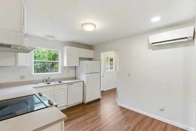 a kitchen with a sink cabinets stainless steel appliances and windows
