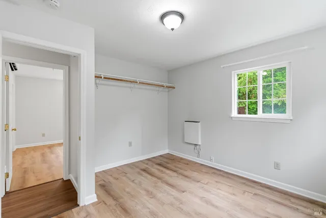 an empty room with windows and closet