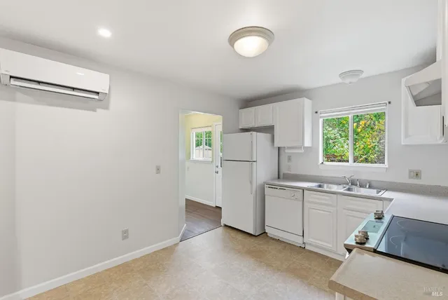 a kitchen with white cabinets and white appliances