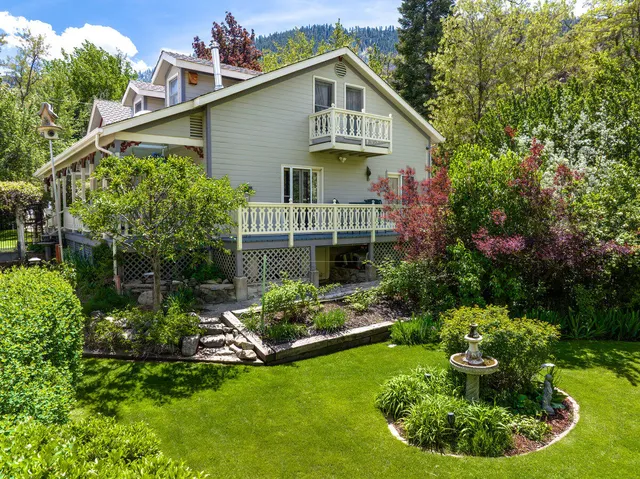 a front view of a house with a yard and potted plants