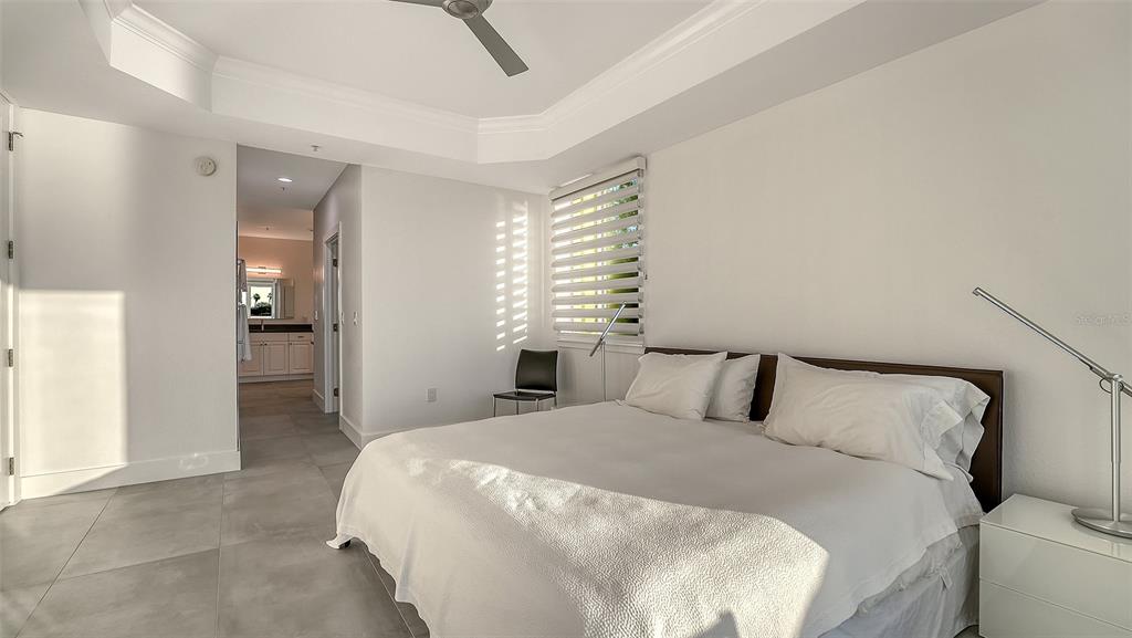 166 Golden Gate Point, Unit 22 Sarasota, FL 34236 - Photo 25 of 49 a bedroom with a large bed and chandelier