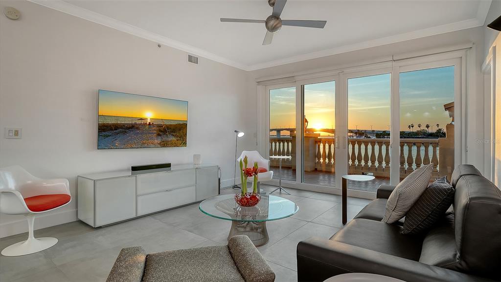 166 Golden Gate Point, Unit 22 Sarasota, FL 34236 - Photo 9 of 51 a living room with furniture a flat screen tv and floor to ceiling window