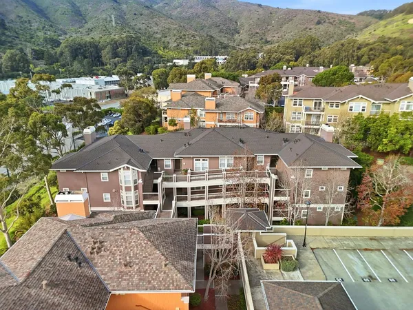an aerial view of a house with a mountain