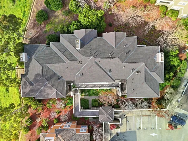 an aerial view of residential houses with outdoor space and trees