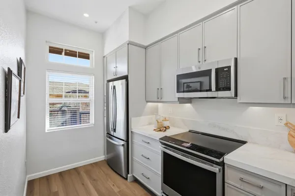 a kitchen with stainless steel appliances granite countertop a refrigerator sink and stove
