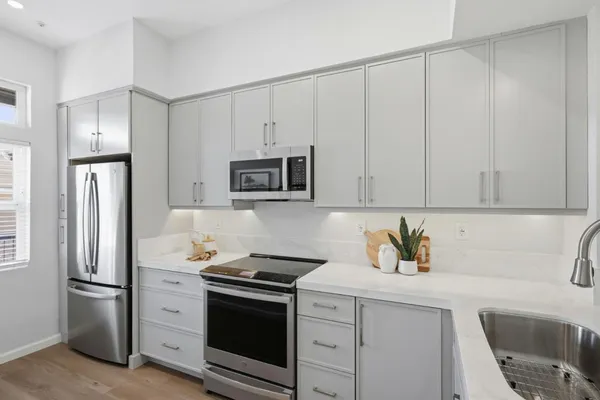 a kitchen with stainless steel appliances white cabinets and a stove top oven