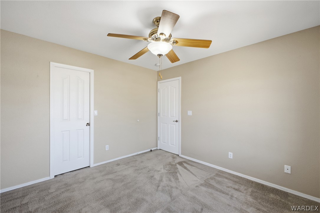 3918 North Eagle Rock Road Kingman, AZ 86409 - Photo 15 of 44 an empty room with a ceiling fan and fan