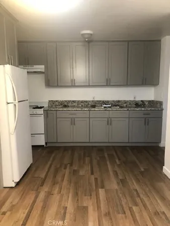 a kitchen with a sink a stove and cabinets