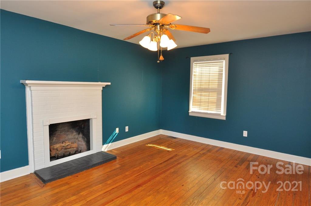 623 Sanders Street Chester, SC 29706 - Photo 3 of 20 a bedroom with a fireplace and a ceiling fan