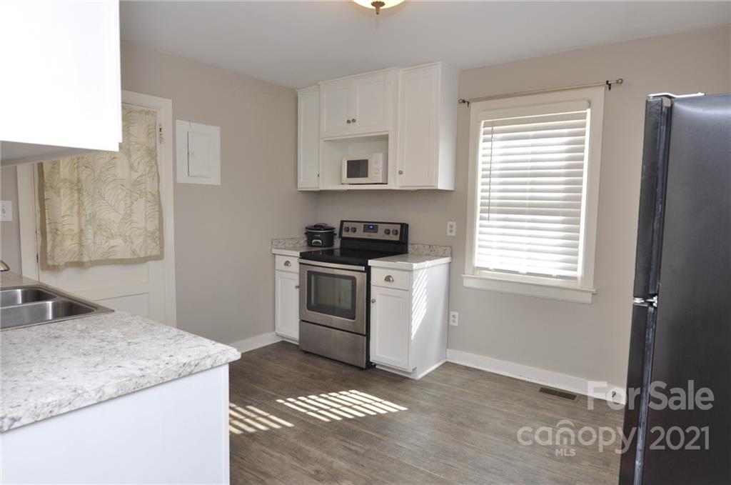 623 Sanders Street Chester, SC 29706 - Photo 5 of 20 a kitchen with granite countertop white cabinets and white appliances