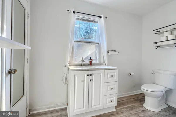 a bathroom with a granite countertop sink a toilet and a mirror