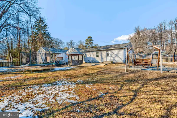 a front view of residential houses with yard and trees in the background