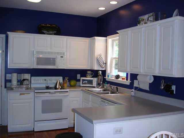 3521 Boren Court Raleigh, NC 27616 - Photo 3 of 10 a kitchen with kitchen island a sink a stove and white cabinets