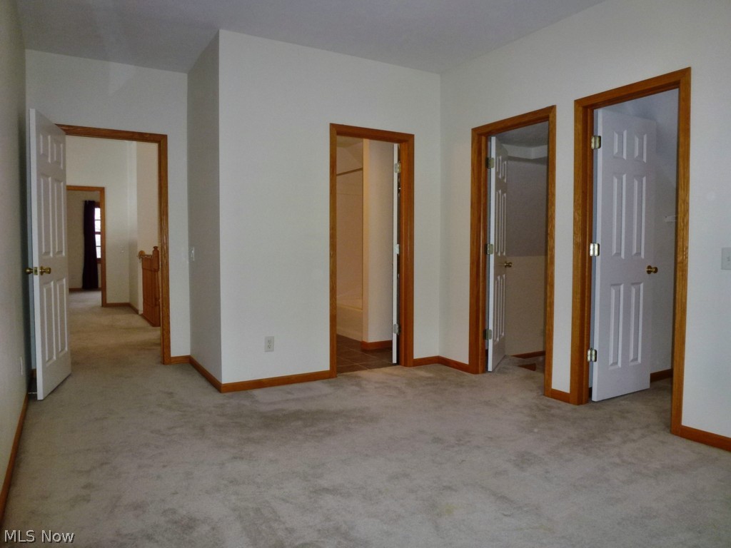 13591 Spring Street Burton, OH 44021 - Photo 14 of 25 Bedroom #2 features 9' ceiling, Walk-in closet, direct access to the full bath and the center door in this view leads into a 20' x 15' Bonus Room.