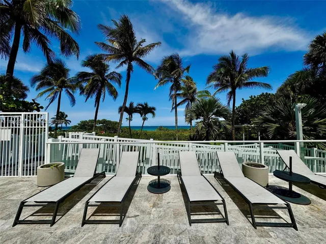 a view of a roof deck with a barbeque and wooden stairs