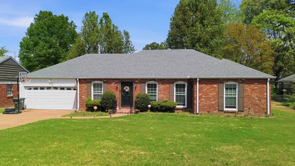 a aerial view of a house with yard and green space