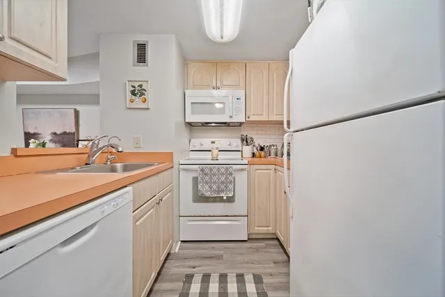 a kitchen with white cabinets and white appliances