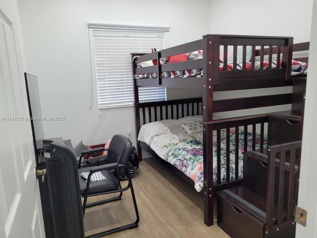 16383 Southwest 44th Terrace Miami, FL 33185 - Photo 12 of 24 a bedroom with a bed and wooden floor