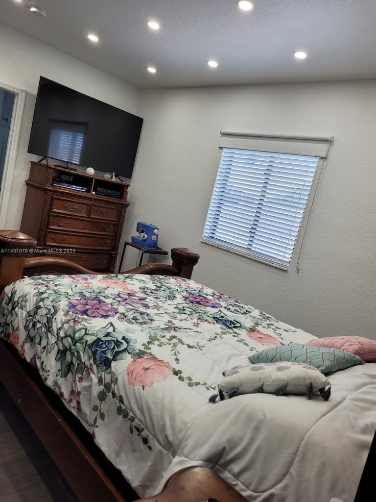 16383 Southwest 44th Terrace Miami, FL 33185 - Photo 19 of 24 a bedroom with a bed and a flat screen tv