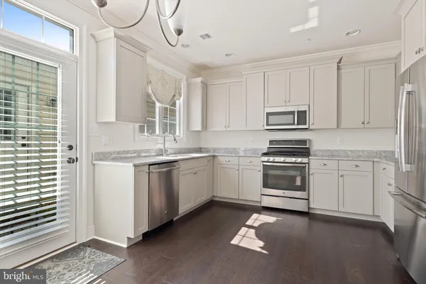 a kitchen with white cabinets and white appliances