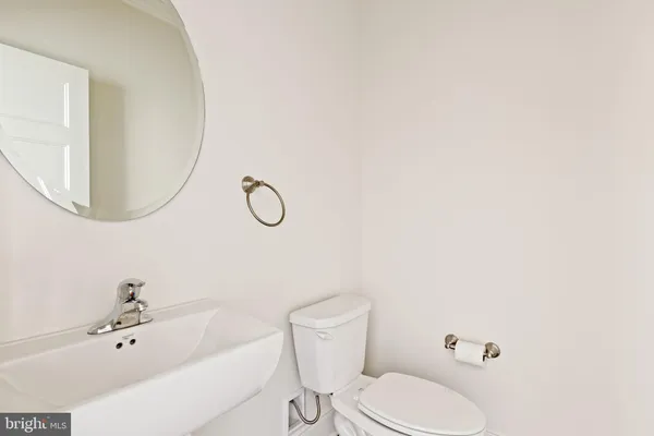 a bathroom with a sink a toilet and mirror