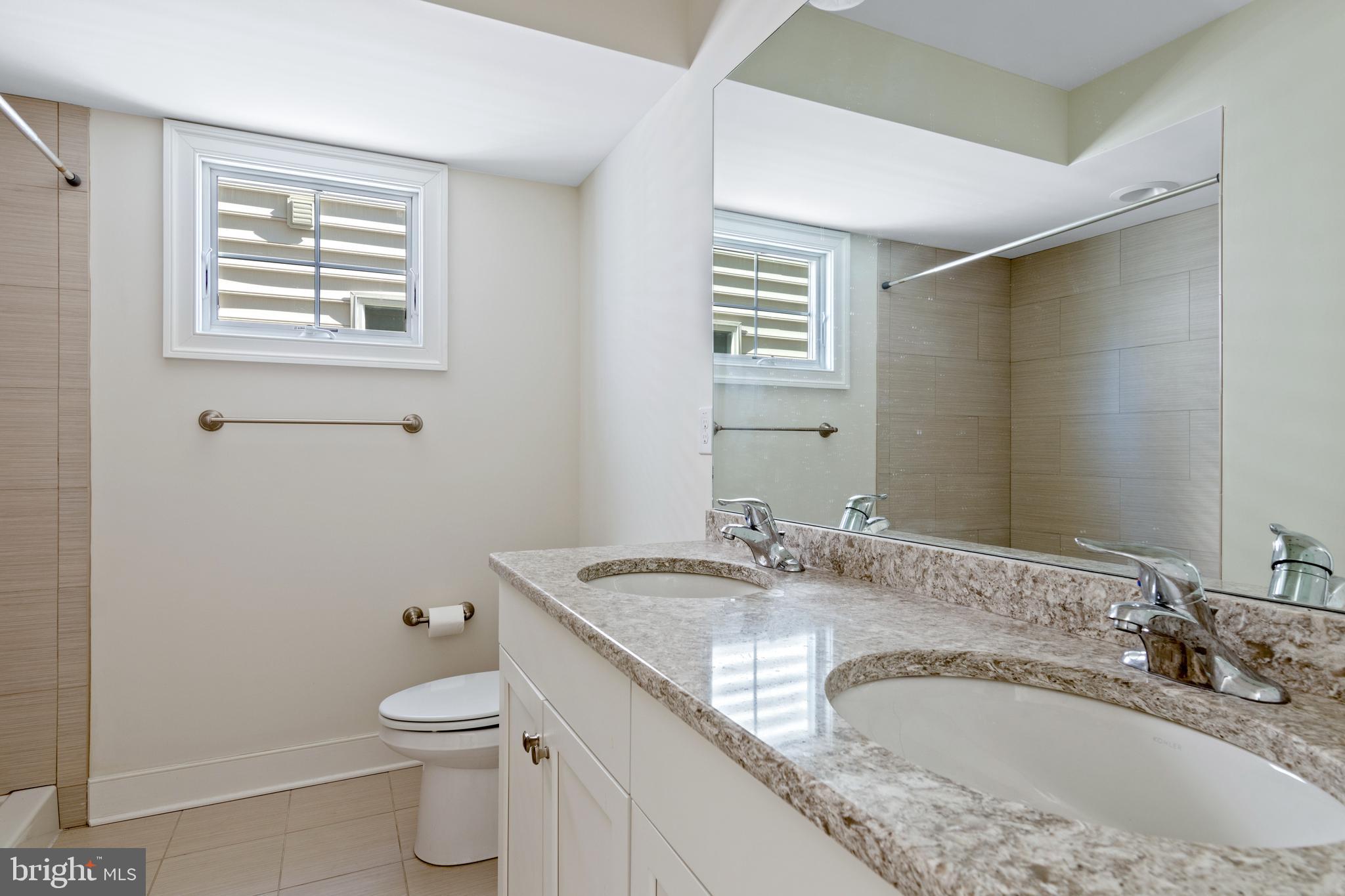 626 D Street Kennett Square, PA 19348 - Photo 17 of 24 a bathroom with a granite countertop sink a mirror and a toilet