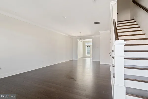 a view of a livingroom with wooden floor and stairs