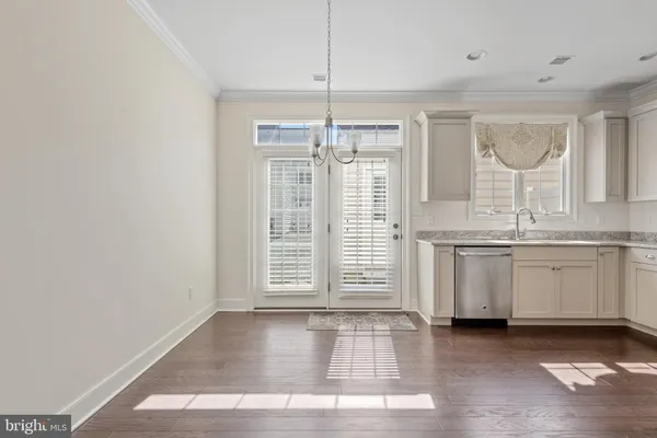 a view of a kitchen with wooden floor and a window
