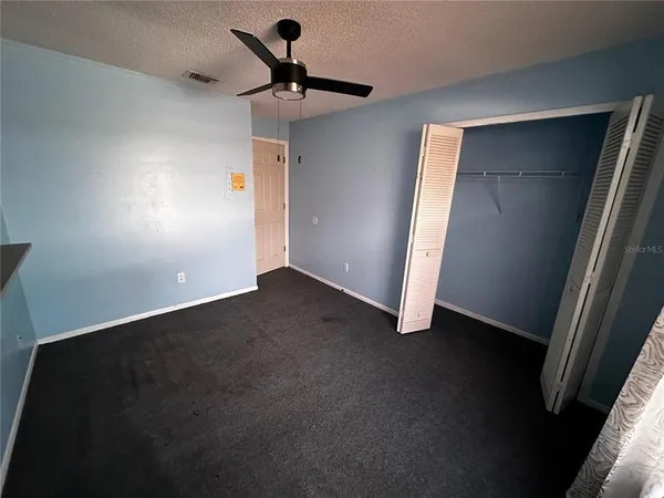 en empty room with windows and fan