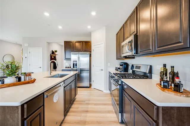 a kitchen with stainless steel appliances granite countertop a sink a stove and a refrigerator