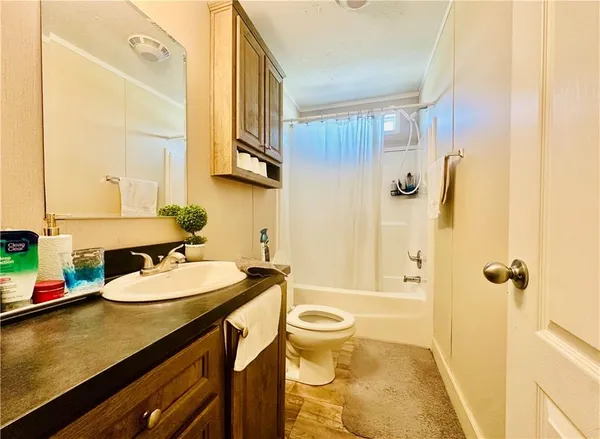 a bathroom with a granite countertop sink toilet and shower