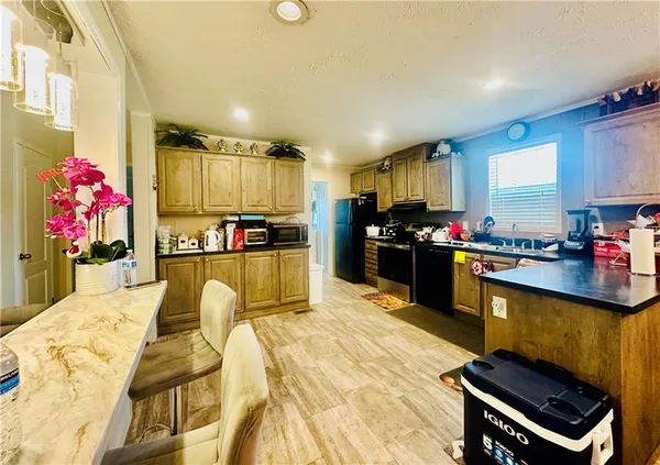 a kitchen with stainless steel appliances kitchen island granite countertop a stove and cabinets