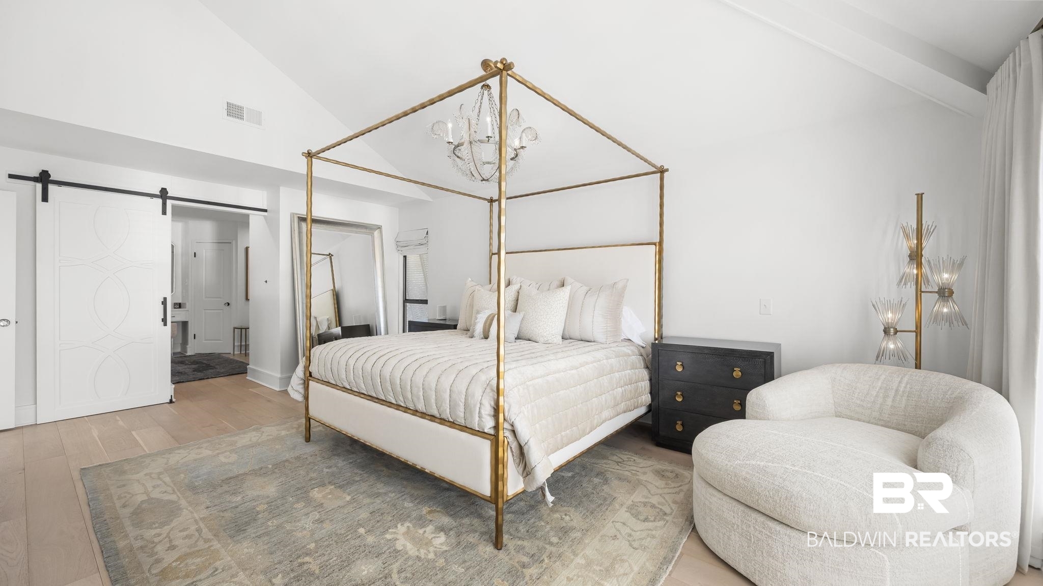 30194 River Road Orange Beach, AL 36561 - Photo 12 of 45 Bedroom featuring a barn door, lofted ceiling, wood finished floors, ensuite bath, and suspended lighting