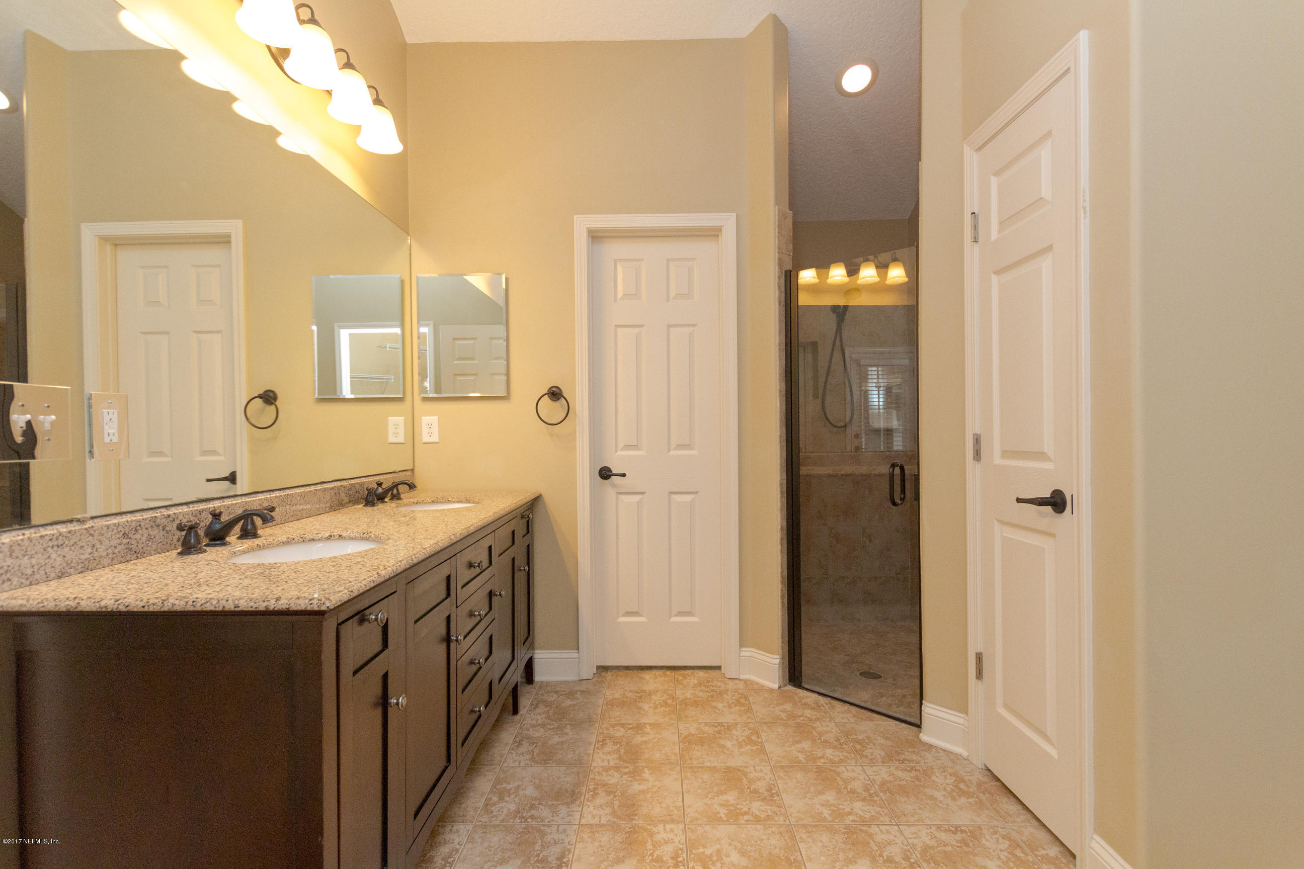 12865 Beaubien Road Jacksonville, FL 32258 - Photo 17 of 28 a bathroom with a double vanity sink and a mirror