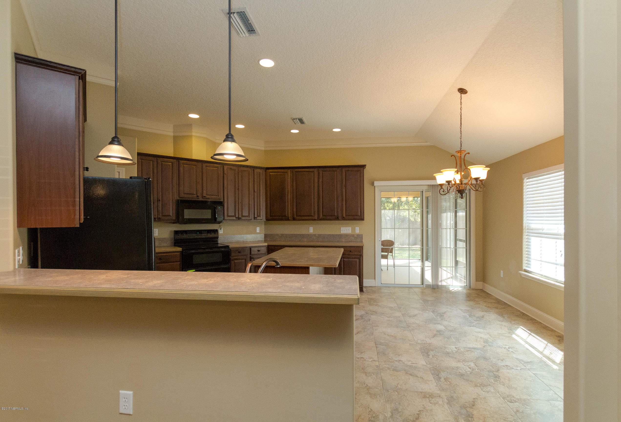 12865 Beaubien Road Jacksonville, FL 32258 - Photo 8 of 28 a large kitchen with a stove a sink dishwasher a refrigerator and a fireplace with wooden floor
