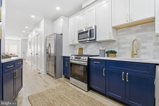 a kitchen with stainless steel appliances granite countertop a refrigerator and a stove top oven