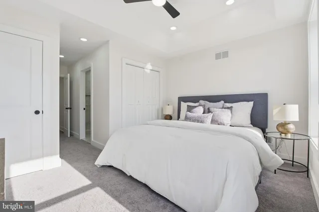 a large bed in a white room with closet