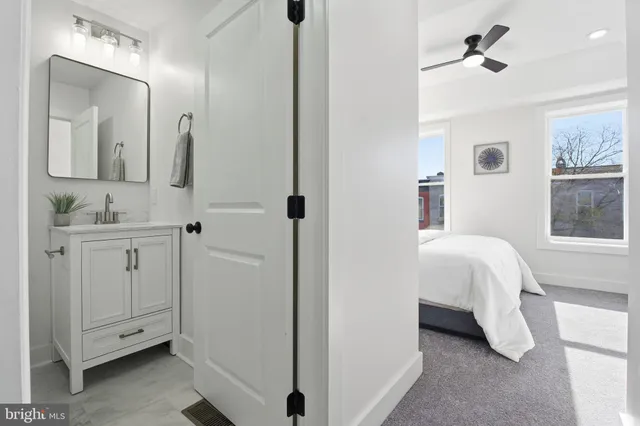 a en suite bathroom with a double vanity sink a mirror and a bathtub