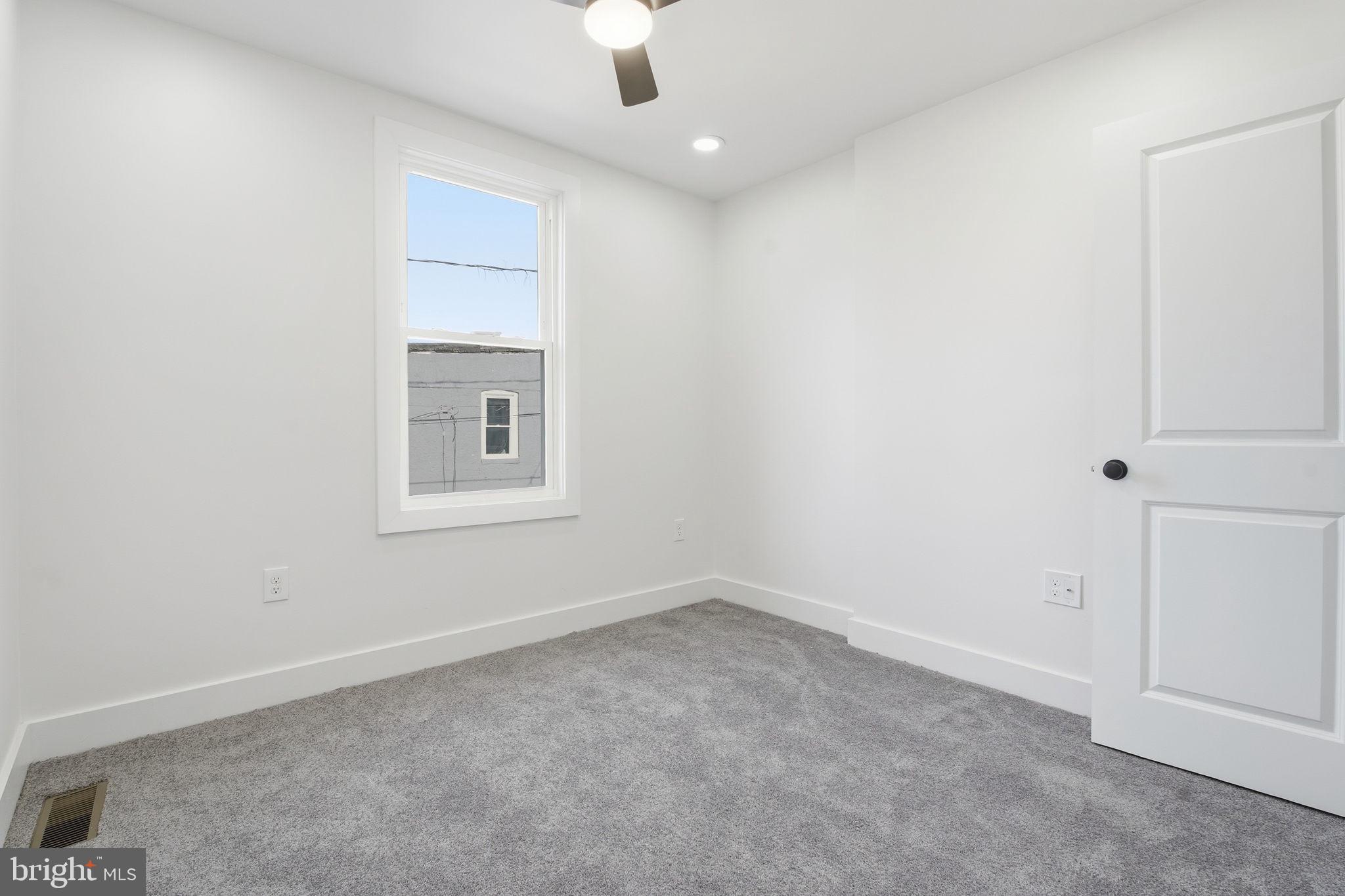 1742 East Oliver Street Baltimore, MD 21213 - Photo 21 of 36 an empty room with a window and ceiling fan