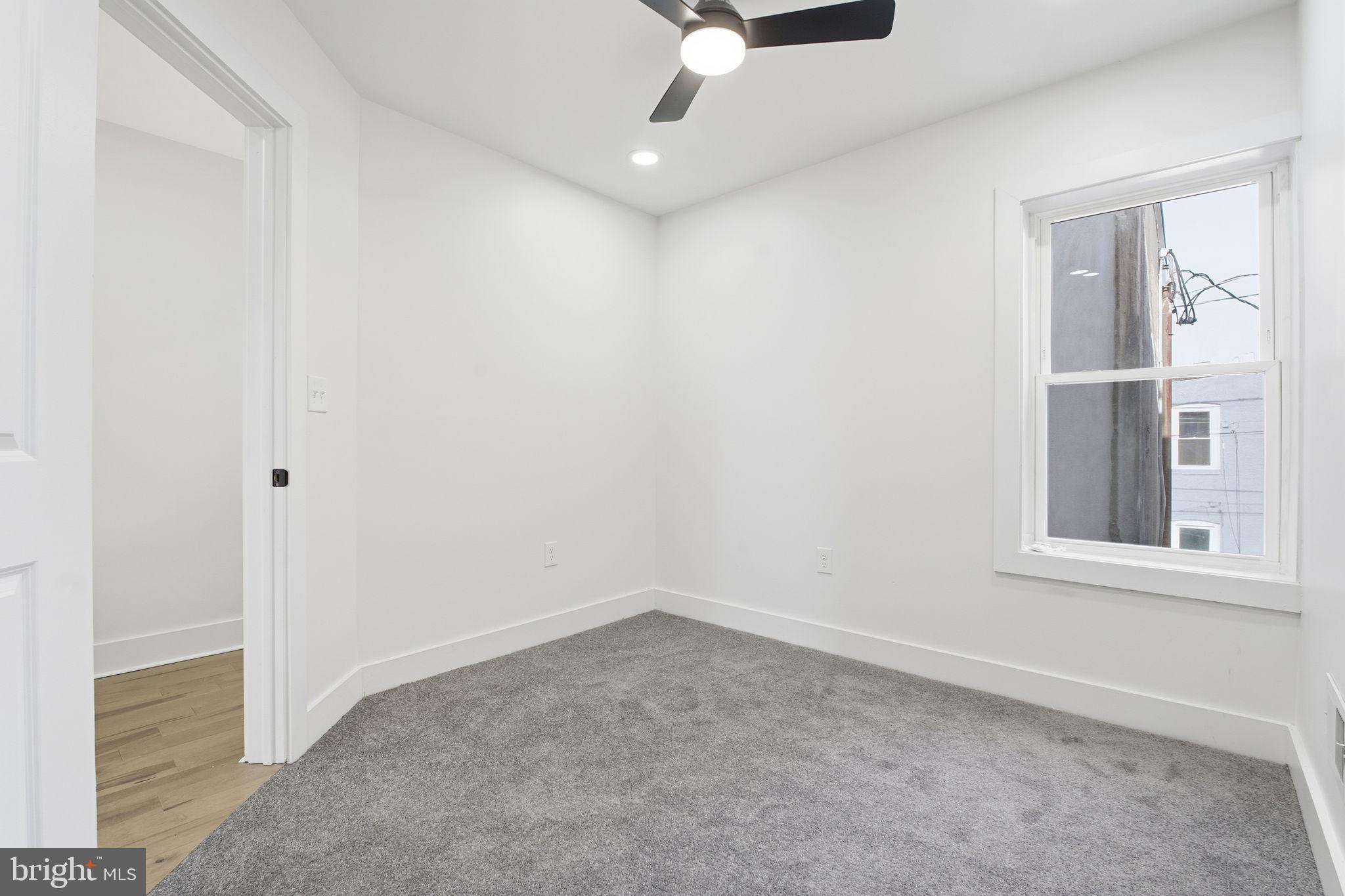 1742 East Oliver Street Baltimore, MD 21213 - Photo 26 of 36 an empty room with windows and ceiling fan