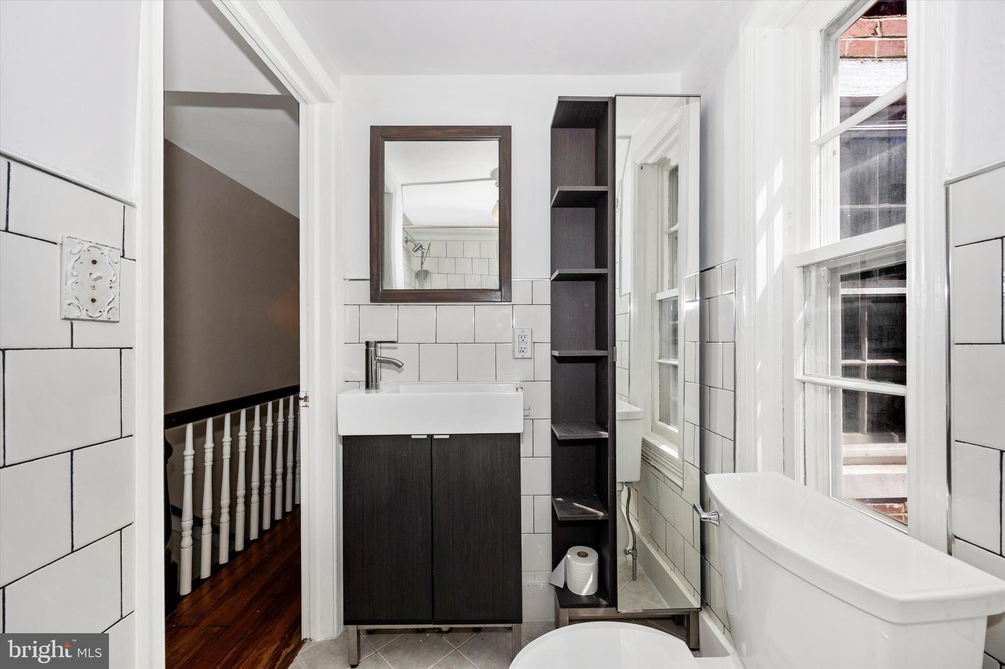 20 East 4th Street Frederick, MD 21701 - Photo 21 of 55 a bathroom with a toilet a sink and a large mirror