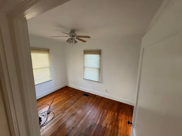 an empty room with a window and a ceiling fan