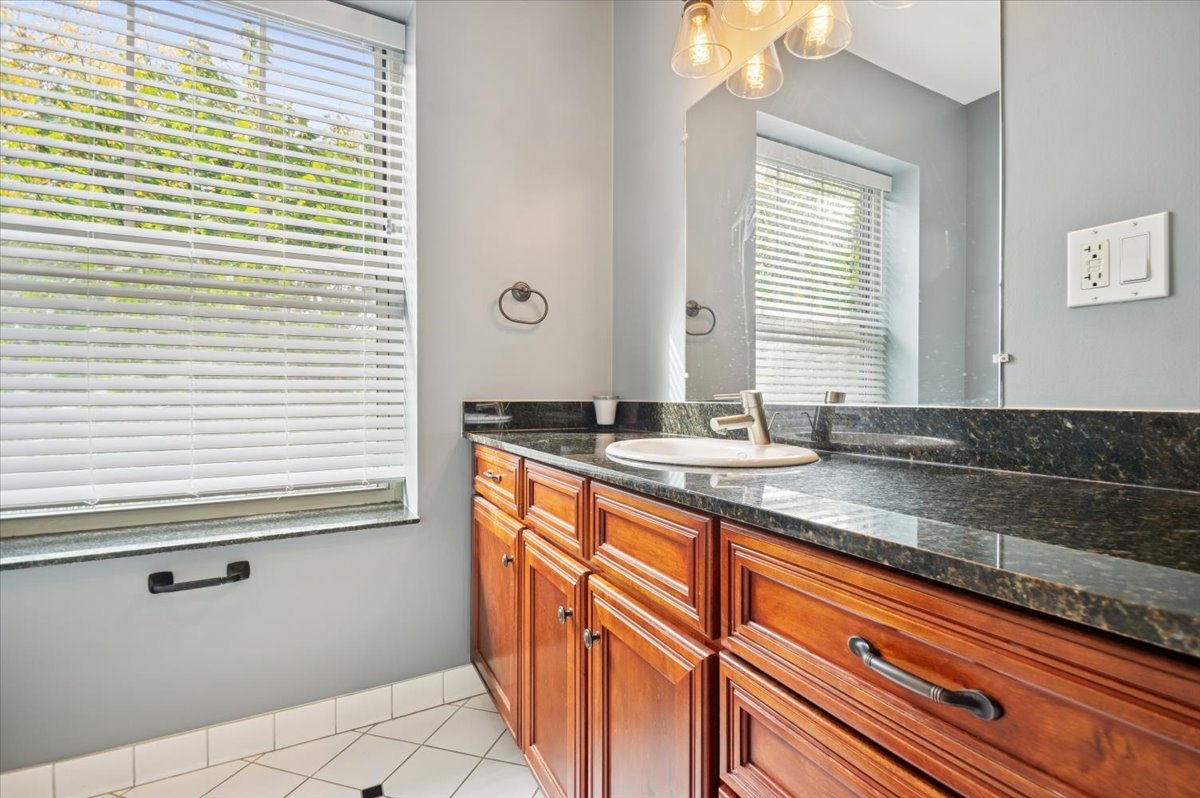 1265 West Granville Avenue, Unit 3 Chicago, IL 60660 - Photo 14 of 15 a bathroom with a granite countertop sink and a mirror