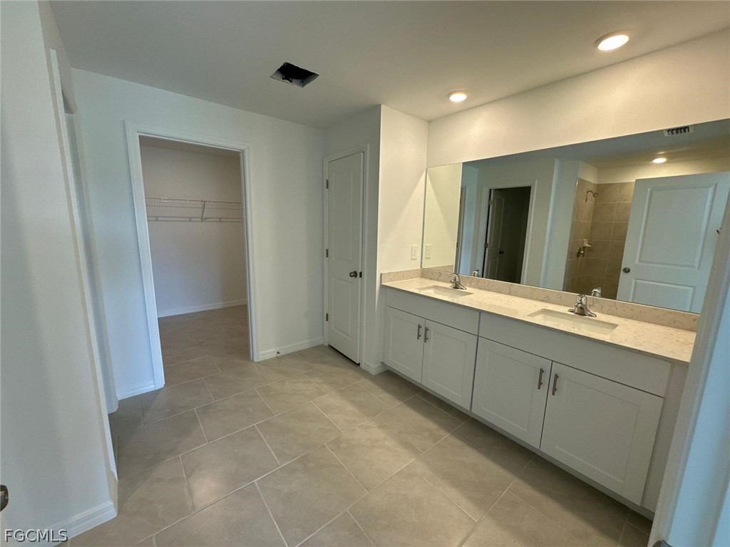 12312 Amber Waves Road Lehigh Acres, FL 33974 - Photo 25 of 32 a bathroom with a double vanity sink and a mirror