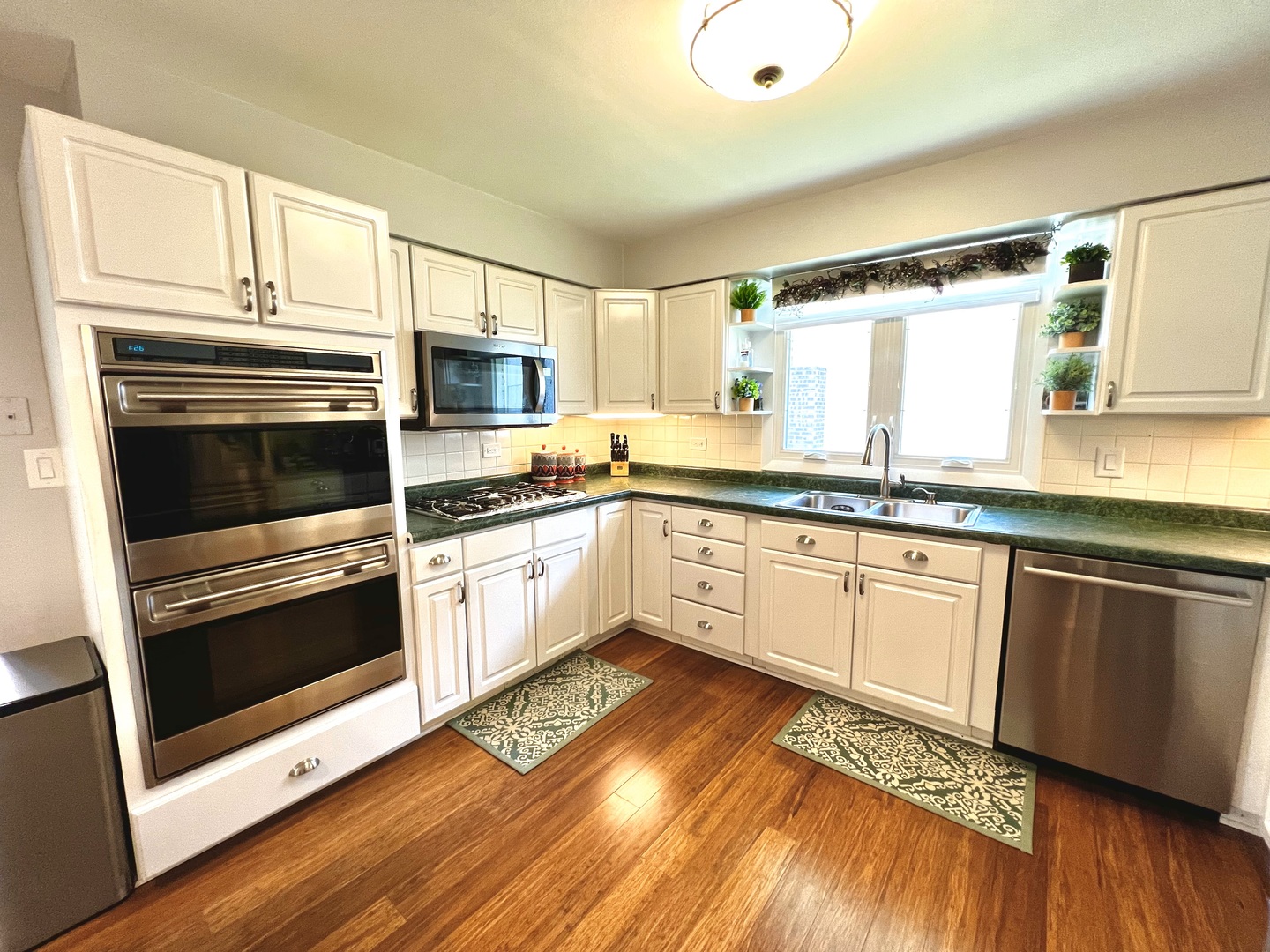 7125 Wirth Drive Darien, IL 60561 - Photo 10 of 38 a white kitchen with granite countertop a stove top oven a sink and dishwasher with wooden floor