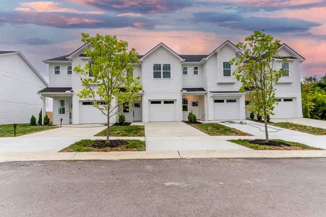 a front view of a house with a yard and a garage