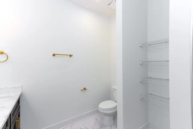 a bathroom with a granite countertop toilet and a sink